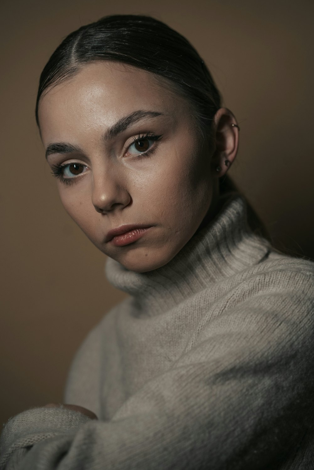 Woman with soft, natural makeup in a neutral turtleneck